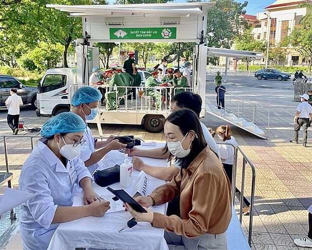 Medical workers talk to residents before COVID-19 vaccinations in the central province of Thua Thien-Hue. Photo: VNA
