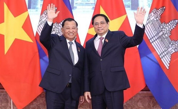 Prime Minister Pham Minh Chinh (R) welcomes  President of the Cambodian Senate Samdech Say Chhum. Photo: VNA