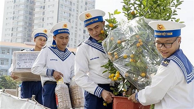 Soldiers carry gifts and goods onto the ships. Photo: VNA