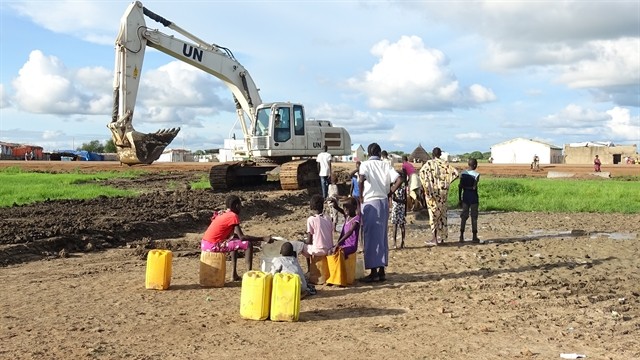 Abyei townspeople gather next to an excavator used for road-making. — Photo courtesy of the Vietnam Department of Peacekeeping Operations