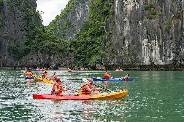 Tourists kayaks across a vast body of water in Ha Long Bay (Photo: VNA)