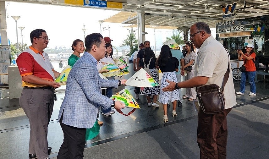 Deputy Director of the Ho Chi Minh City Department of Tourism Le Truong Hien Hoa presents Non La (Vietnamese conical hat) to Indian tourists.