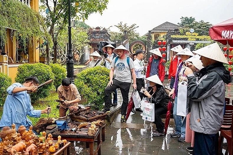 A procession wearing ao dai (Vietnamese traditional dress) passes through a street in Hanoi Old Quarter. (Photo: VNA) 