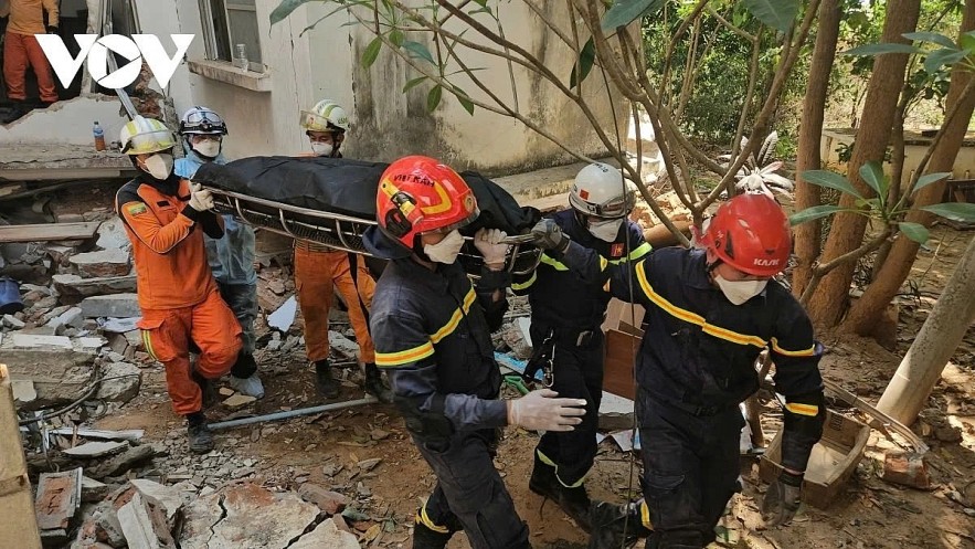 Vietnamese rescue workers retrieve a dead body of a 15-year-old boy from rubble in Myanmar.