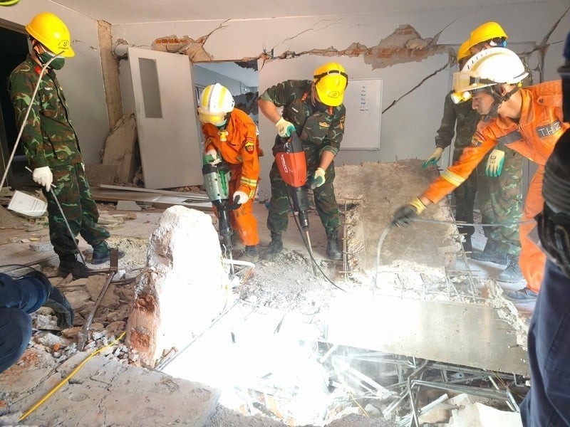 Vietnamese combat engineers and Myanmar, UAE rescue teams drill through concrete to reach buried victims.