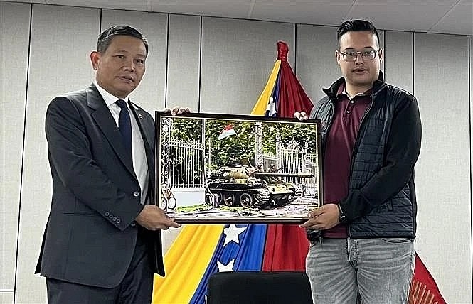Vietnamese Ambassador to Venezuela Vu Trung My (left) presents a photo of the April 30 victory to a representative of the Antonio Jose de Sucre International Youth Leadership Training School. (Photo courtesy of the Vietnamese Embassy in Venezuela) Vietnamese Ambassador to Venezuela Vu Trung My (left) presents a photo of the April 30 victory to a representative of the Antonio Jose de Sucre International Youth Leadership Training School. (Photo courtesy of the Vietnamese Embassy in Venezuela)