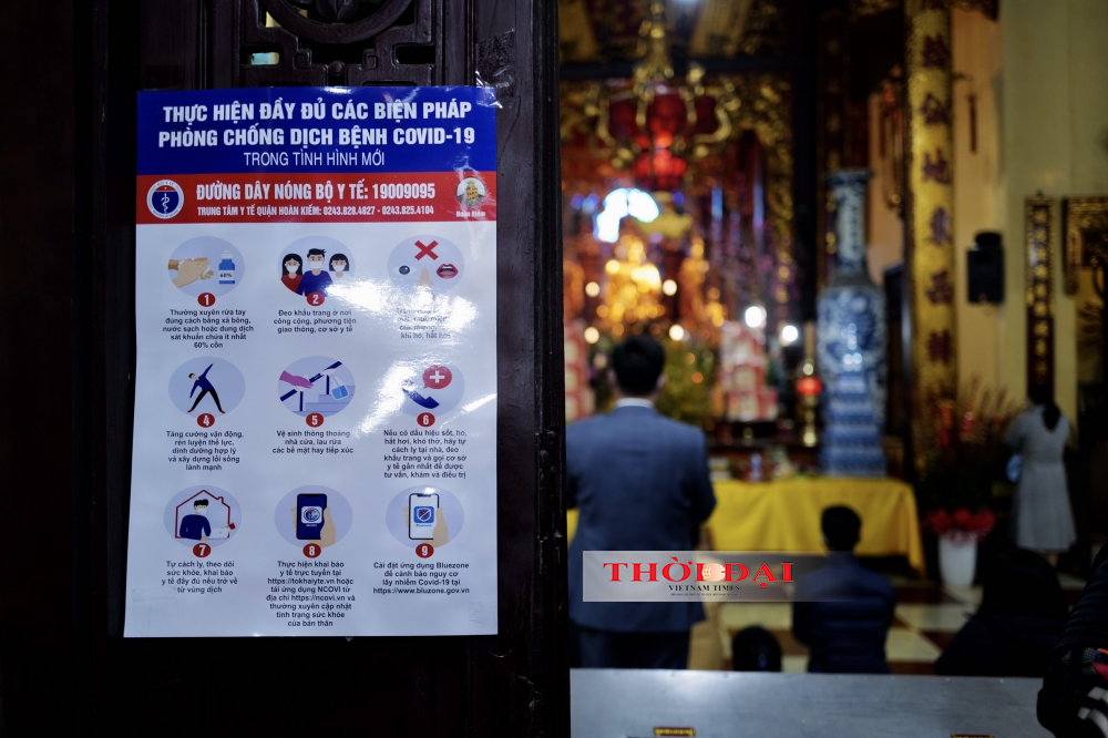 People follow Covid-19 safety protocol while visiting Quan Su pagoda
