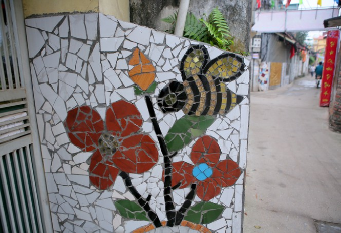 Colorful village road created by discarded bottles and scrap