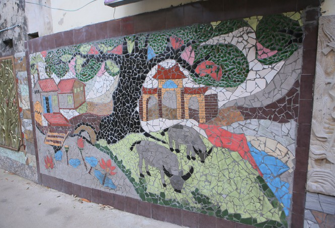 Colorful village road created by discarded bottles and scrap