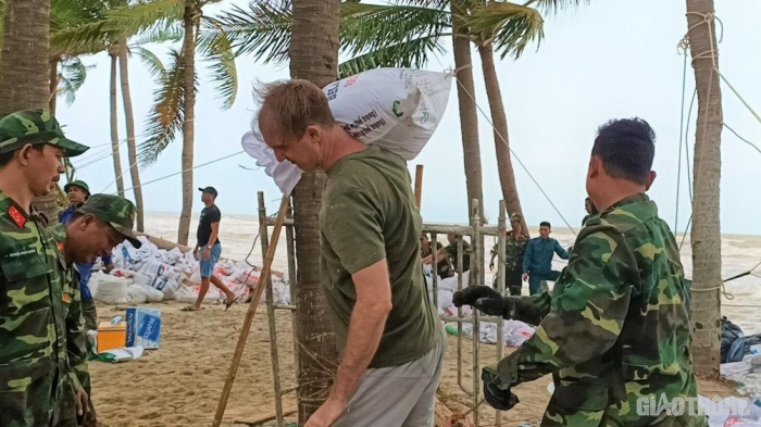 Foreign visitors join hands with Vietnamese to pile up ring dyke before storm in Hoian