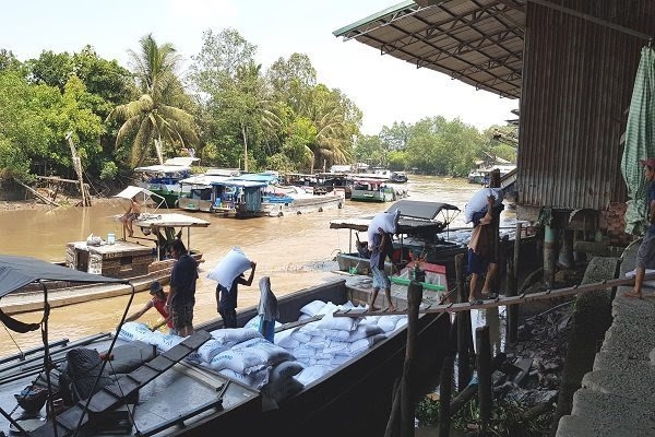 Workers move rice sacks from a boat to warehouse in the mekong delta province of tien giang. vietnam is expected surpass thailand exports