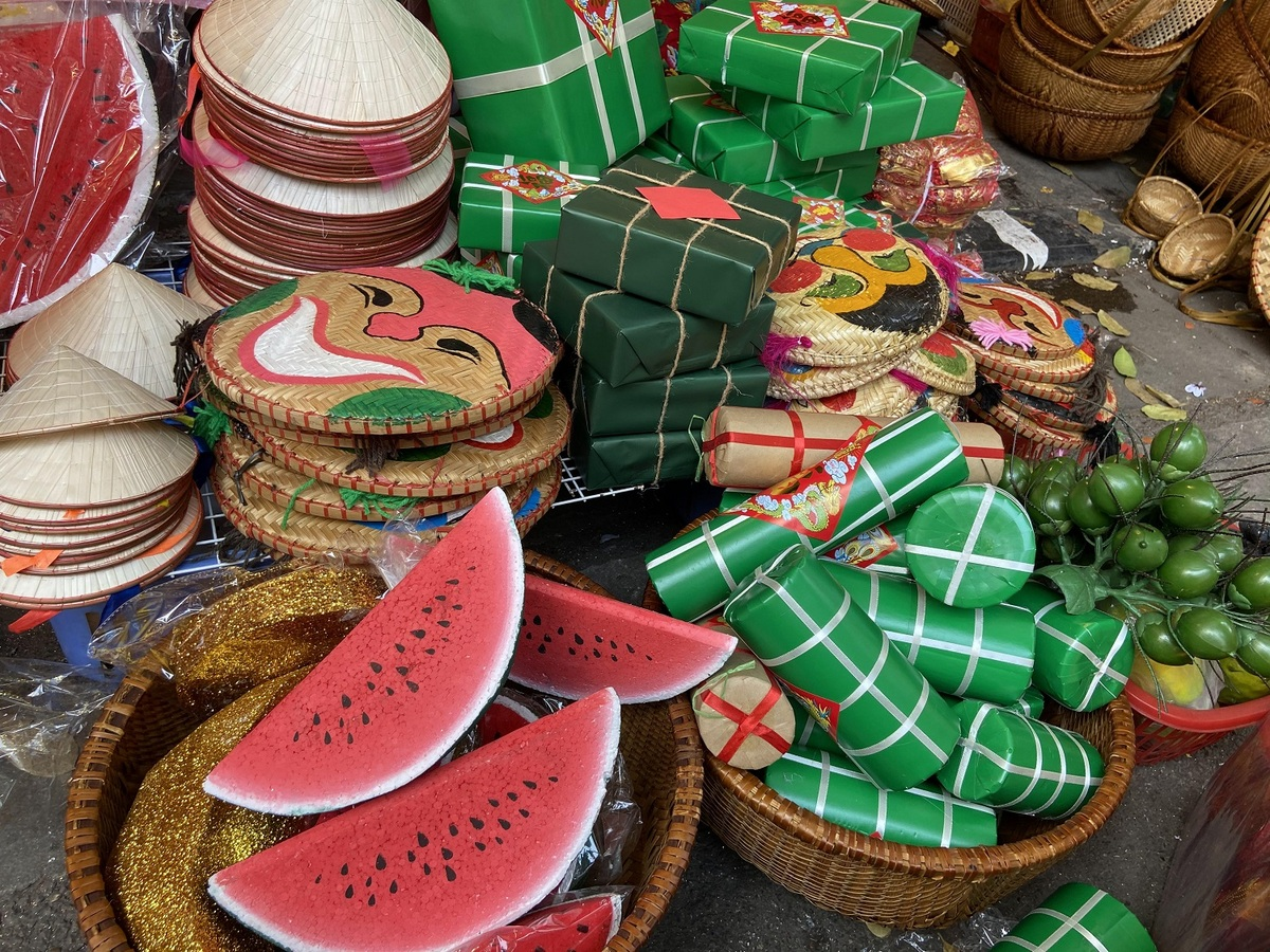 Traditional Tet-style decorations like paper watermelons, sticky rice cakes (banh chung) and cylindric glutinous rice cakes (banh tet) are up for sale, from VND60,000. (Photo: VnExpress) 4115 ct8 1612157692