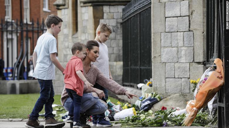 A family put flowers outside Windsor Castle (Photo: CNN) 