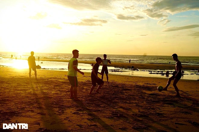 Children playing football on the beach at dawn. Photo: Dantri 
