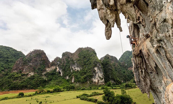 The mountain scenery at Huu Lung District, Lang Son Province. Photo courtesy of VietClimb. Intrepid travelers seeking adrenaline pumping thrill can choose to conquer virtually vertical mountain slopes in Lang Son Province. Yen Thinh Commune in Lang Son's Huu Lung District has a network of big mountains, many of them with vertical slopes. Provincial authorities are now looking to tap the commune's adventure tourism potential as a signature product, and a new rock climbing tour has been launched.  There are five main climbing spots now, with more than 110 climbing paths at many different levels. Two tours are offered every month for travelers to try and scale the tough slopes.  The price for a two-day-one-night tour is VND2.7 million ($116), and a one-day tour is VND1.3 million. The cost includes catering services, sleeping spot, climbing equipment, guide and transportation. Visitors who do not have specialized climbing shoes can rent a pair for VND100,000 a day.  The tours will have a technical assistant to help people climb to the top safely. As another safety measure, a maximum of 20 people are allowed to climb at one spot.  The rock climbing tour in Yen Thinh Commune, Lang Son Province. Photo courtesy of the Vietnam National Administration of Tourism.