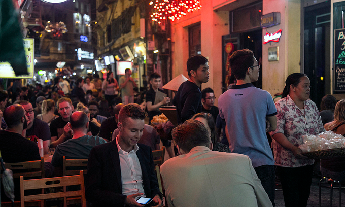 Foreign tourists sit at a beer stall in Ta Hien-Luong Ngoc Quyen intersection in Hanoi, 2019. Photo by VnExpress/Giang Huy.