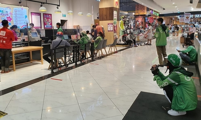 Grab motorbike drivers wait for orders at Aeon Mall Ha Dong Supermarket in Ha Dong District, Hanoi on July 7, 2021. Photo by VnExpress
