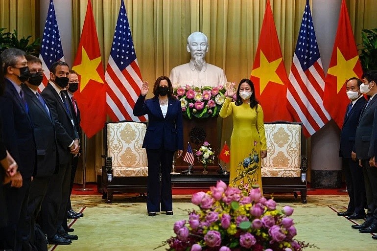 US Vice President Kamala Harris (left) waves beside Vietnam's Vice President Vo Thi Anh Xuan at the Presidential Palace in Hano