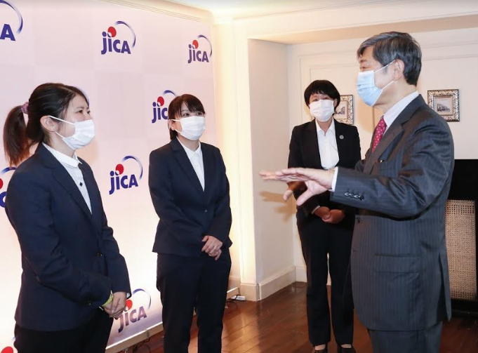 Photo 1: JICA President (the one standing outside, right) talks with the volunteers 4925 jica