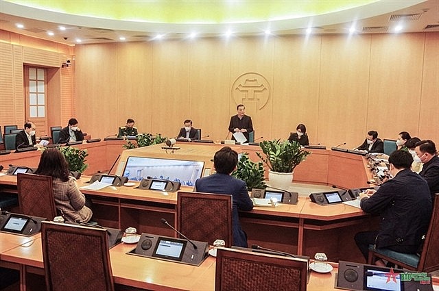 Chairman of the Hà Nội People's Committee Chu Ngọc Anh (standing) speaks at a meeting with local authorities on COVID-19 prevention on Sunday. Photo qdnd.vn