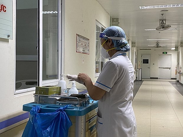 A health worker prepares to tend to COVID-19 patients at a hospital. Photo: VNA