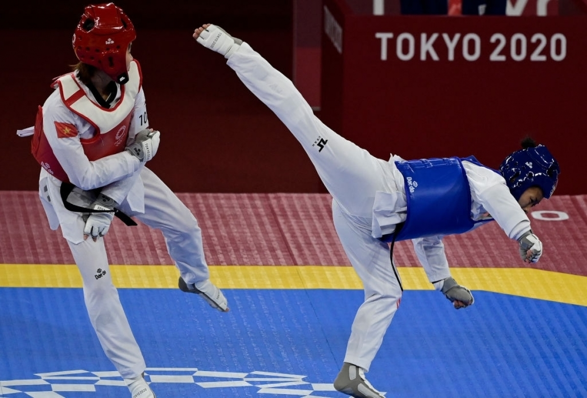 Kim Tuyen (in red gi) defeats Yvette Yong of Canada to enter the quarter-finals. Photo: Getty
