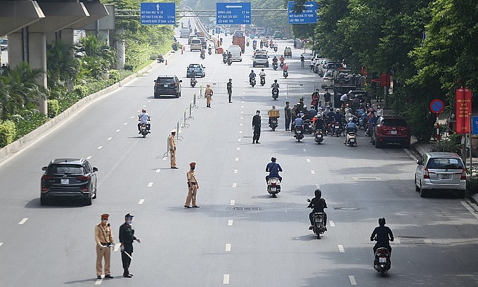 Police officers patrol on a Hanoi street amid a Covid-19 social distancing order, August 17, 2021. Photo: VnExpress