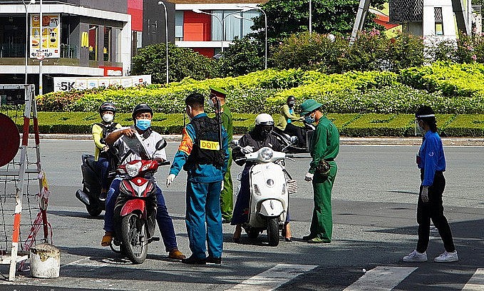 Forces check travel papers of people at a Covid checkpoint on Nguyen Binh Khiem Street in HCMC, August 23 2021. Photo: VnExpress