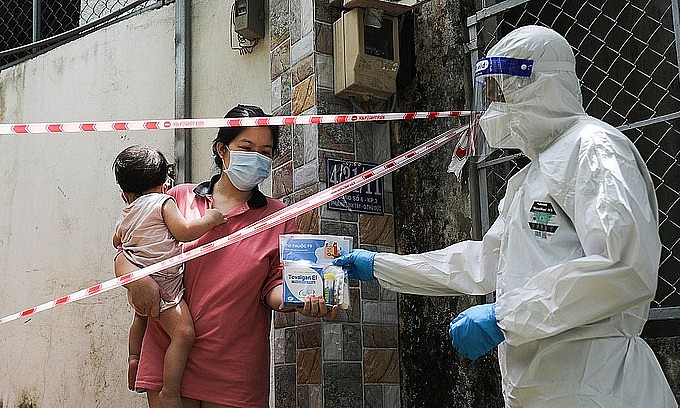 A medic hands a package of medicine for Covid-19 patient to a HCMC resident, September 3, 2021. Photo: VnExpress