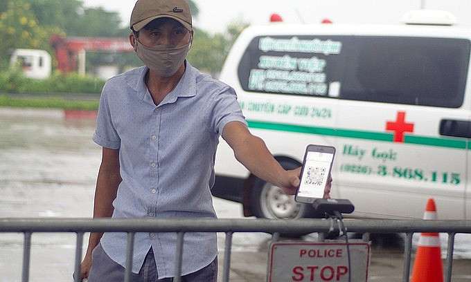 A man scans a QR code at a Covid-19 checkpoint to enter Hanoi, September 14, 2021. Photo: VnExpress