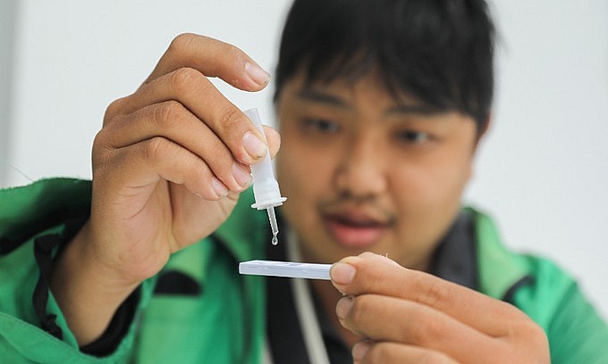 A shipper conducts his own Covid-19 rapid test in Binh Thanh District, Ho Chi Minh City on Sept. 29, 2021. Photo: VnExpress