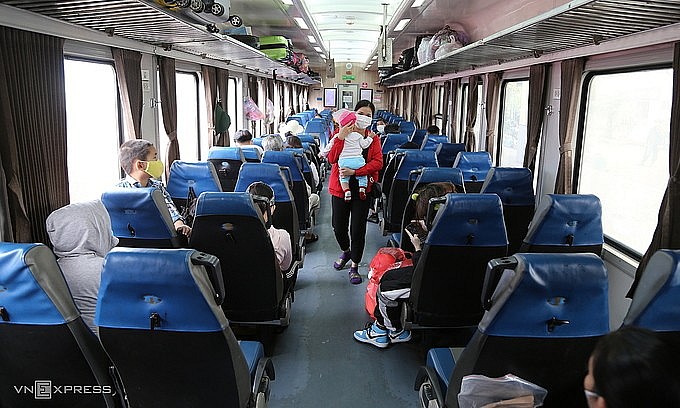 A woman carrying her baby on a train carrying migrant workers in HCMC home in central Vietnam, October 8, 2021. Photo: VnExpress