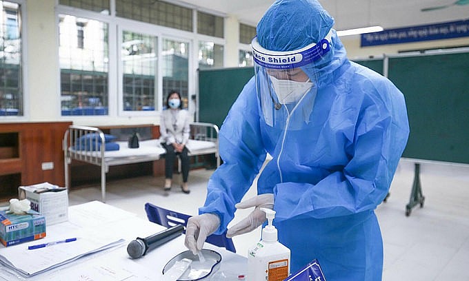 A medical worker practices steps to take care of a Covid-19 patient isolated at home in Ba Dinh District of Hanoi, November 2021. Photo: VnExpress