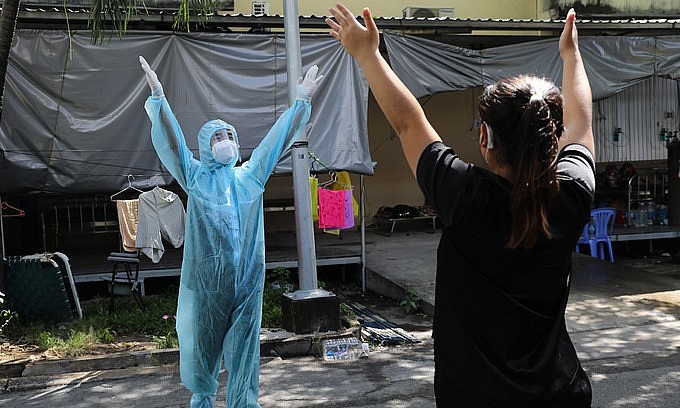 A health worker instructs a Covid-19 patient on how to do physical therapies to restore lung functions in HCMC's District 8, September 21, 2021. Photo: VnExpress