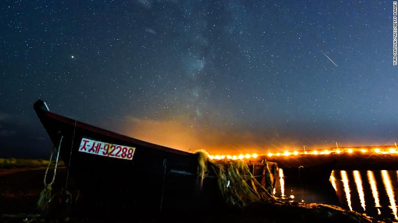 A meteor streaks across the night sky over Russky Island during the Draconid meteor shower in 2018.